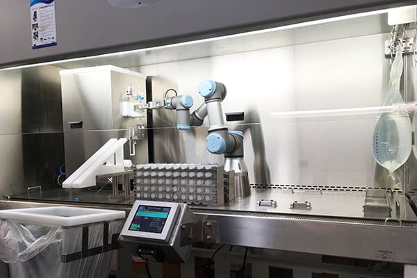 Custom biosafety cabinet equipped with robotic arm for automated syringe filling, featuring integrated touchscreen control and sterile workspace for pharmaceutical applications.