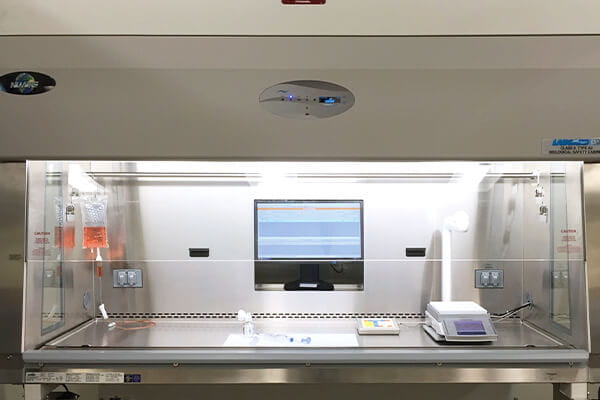 biosafety cabinet with integrated monitor and scale setup for automated hazardous drug compounding in a pharmacy cleanroom environment